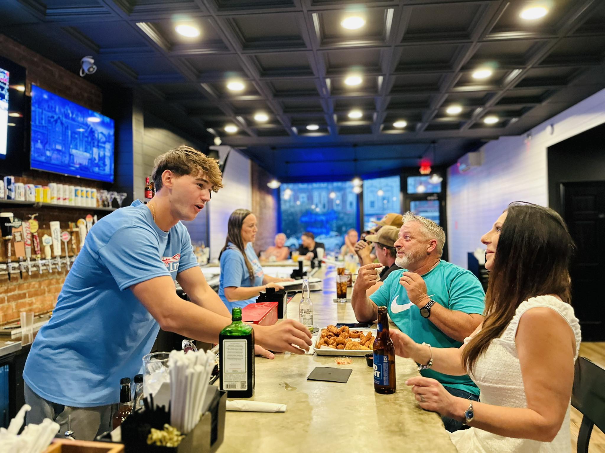 Wings being served at the busy bar with warm atmospheric lighting