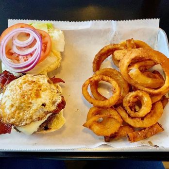 Breakfast burger with fried egg, bacon, and golden onion rings