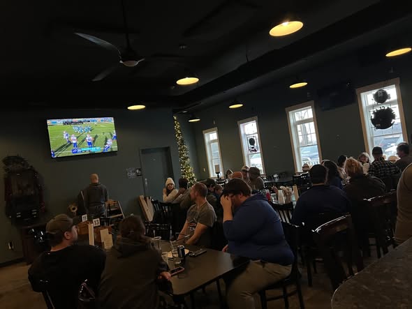 Dining room full of customers watching football on TV
