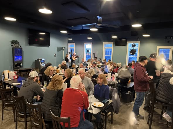 Packed dining room during a live music event with the full crowd engaged