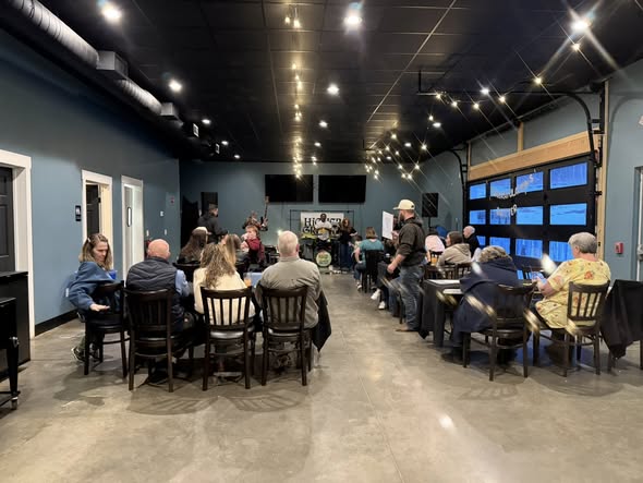 Event space with a live musician performing to a seated audience in an intimate setting