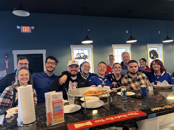 Group of friends at the bar with pizza, Bills gear, having a great time