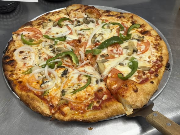 Whole veggie lovers pizza with green peppers, onions, tomatoes, and mushrooms