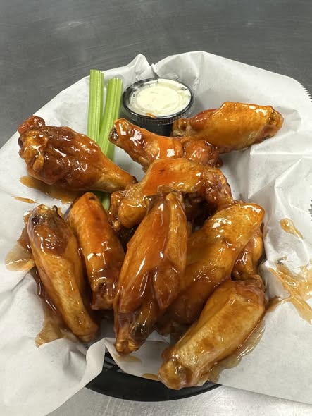 Classic honey-glazed bone-in wings with ranch and celery in warm lighting